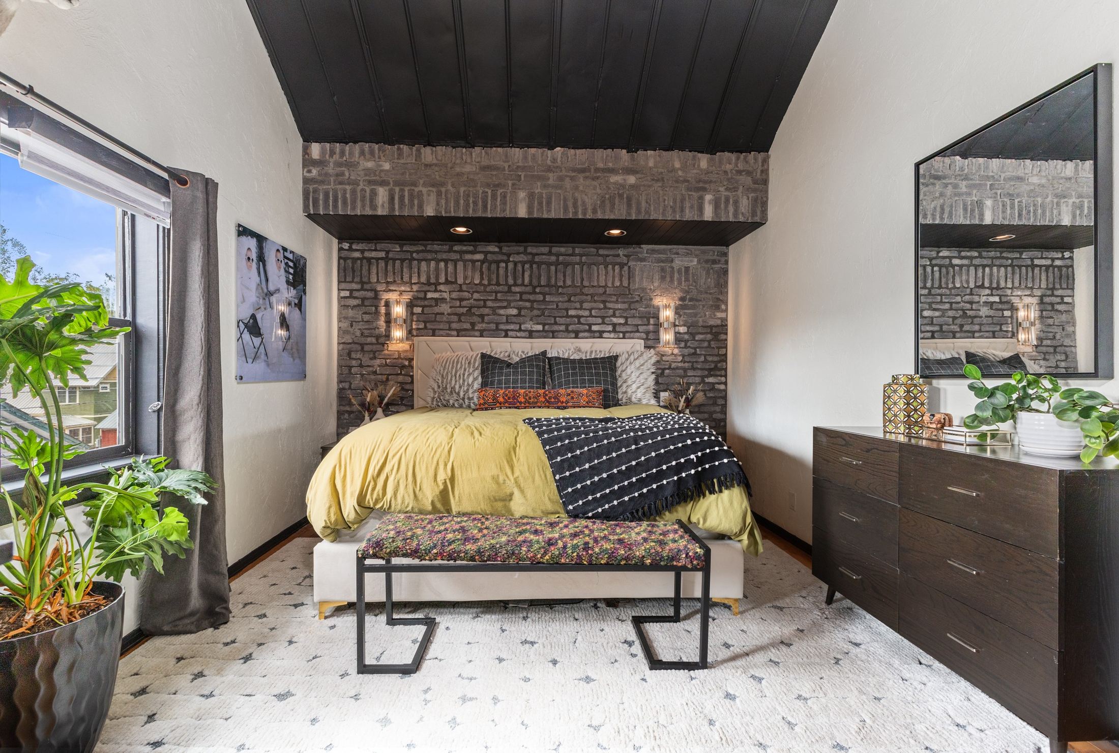 Primary bedroom, exposed brick and brass sconces