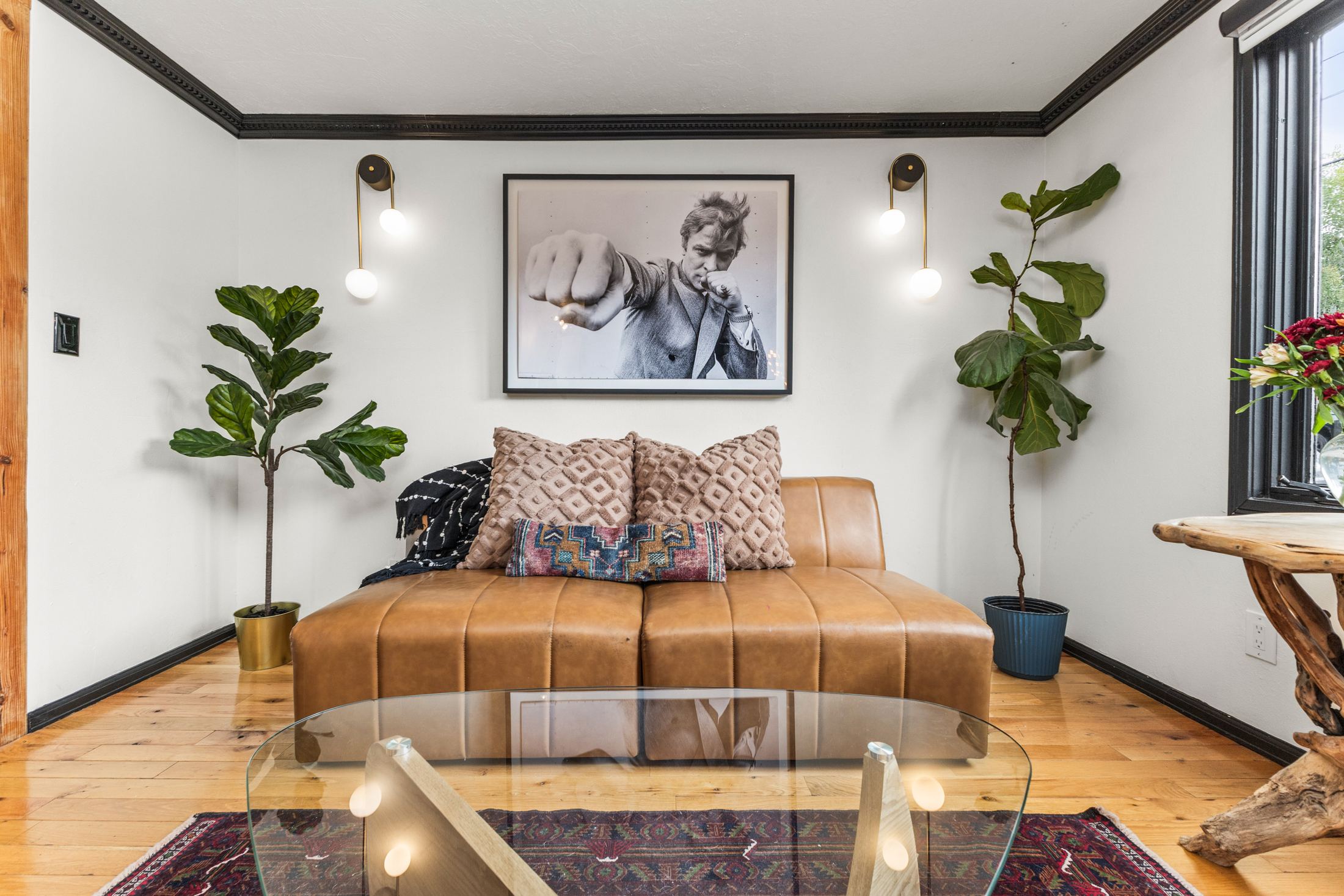 Den with fiddle-leaf figs and vintage photography