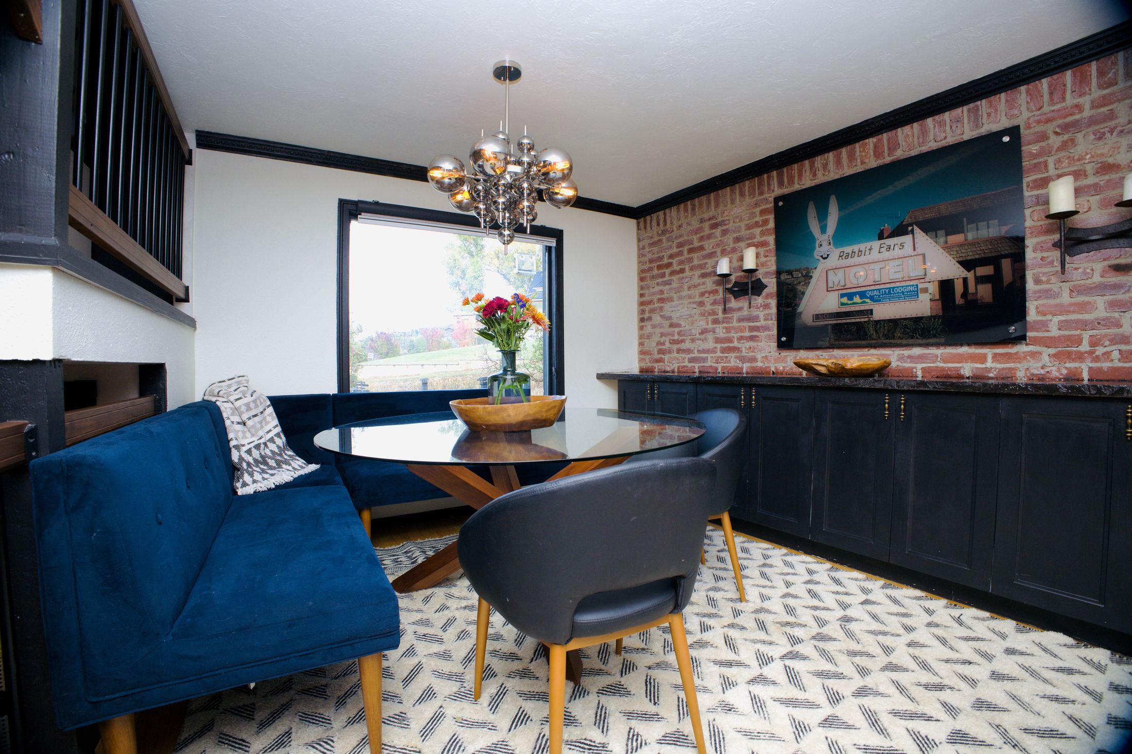 Dining area with brass chandelier and brick wall